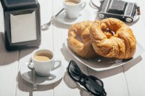 Еспресо кавові чашки і круасани — стокове фото