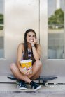 Charmantes Mädchen mit Popcorn auf Schlittschuhen — Stockfoto