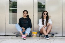 Stylische Teenager mit Popcorn auf Schlittschuhen — Stockfoto