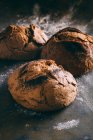 Mains de pain rustique sur sombre — Photo de stock