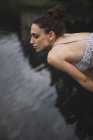 Girl bending forward above water — Stock Photo
