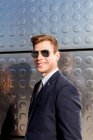Empresário elegante com óculos de sol posando na rua — Fotografia de Stock
