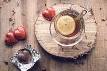 Tea with lemon and chocolate red hearts — Stock Photo