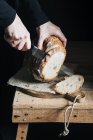 Woman cutting homemade bread — Stock Photo