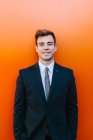 Glücklicher Geschäftsmann posiert gegen orangefarbene Wand — Stockfoto