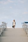 Vue arrière de la femme d'affaires blonde élégante au sommet des escaliers urbains — Photo de stock