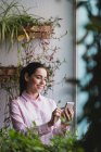 Портрет деловой женщины, стоящей у окна и просматривающей смартфон — стоковое фото