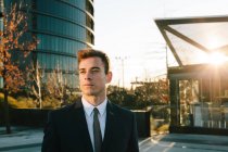 Empresário confiante em terno posando ao pôr do sol de rua — Fotografia de Stock