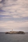 Маяк над скалами на острове — стоковое фото