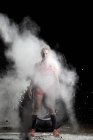 Female in standing in clouds of powder — Stock Photo