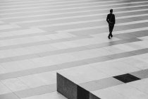 Empresário Caminhando através de um chão listrado — Fotografia de Stock