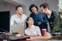 Gente d'affari sorridente che parla al posto di lavoro di collega a ufficio — Foto stock