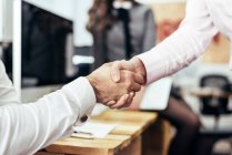 Partners shaking hands confirming deal at office — Stock Photo