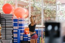 Mulher atlética que se estende no ginásio — Fotografia de Stock