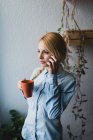 Портрет молодої блондинки, що тримає чашку і розмовляє телефоном — стокове фото