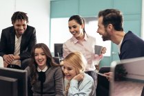 Cheerful colleagues laughing at workplace in officer — Stock Photo