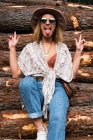 Mujer joven hipster posando en troncos - foto de stock