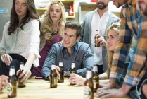 Office team sitting at table and drinking beer. — Stock Photo