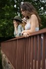 Vista lateral de las niñas en el puente - foto de stock