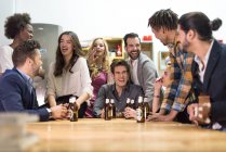Gente che ride con la birra alla festa in ufficio — Foto stock