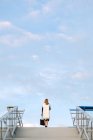 Вид на стильную женщину, позирующую на вершине городской лестницы над небом — стоковое фото