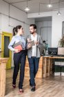 People discussing and walking near desks in the office. Vertical indoors shot — Stock Photo
