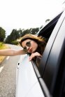 Stylish girl looking out of car window — Stock Photo