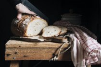 Женщина режет домашний хлеб — стоковое фото