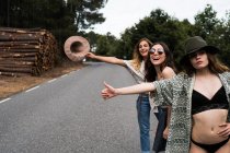 Women hitchhiking on road — Stock Photo