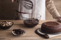 Femme cuisine gâteau au chocolat noir — Photo de stock