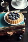 Gâteau aux myrtilles sur de vieux livres — Photo de stock