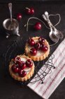 Tartlets filled with cream and cherries — Stock Photo