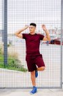 Молодий спортсмен позує на паркані — стокове фото