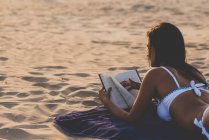 Woman reading book at the beach — Stock Photo