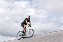 Пенсійний молодий чоловік в шапці на велосипеді — стокове фото