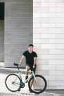 Человек в черном с велосипедом — стоковое фото
