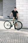 Man in black with his bike — Stock Photo