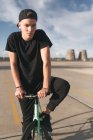 Хлопчик у футболці та кепці з велосипедом — стокове фото