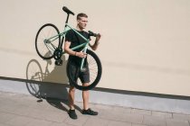Junge trägt Fahrrad — Stockfoto
