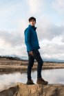 Jeune homme posant contre le lac — Photo de stock
