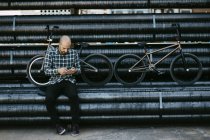 Pilota BMX maschio con telefono — Foto stock