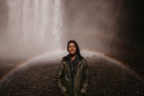 Girl in rainbow of waterfall — Stock Photo
