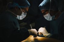 Deux chirurgiens avec lancettes faisant l'opération — Photo de stock
