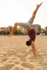 Man In handstand on beach — Stock Photo