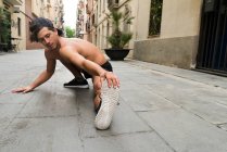 Junger Mann streckt sich auf Straße — Stockfoto