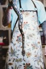 Tattooed man wearing apron holding big snake. — Stock Photo