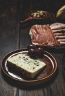 Cheese with grape on rural plate — Stock Photo