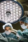 Хирурги стоят и оперируют — стоковое фото
