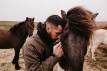 Mann stützt sich auf Pferd — Stockfoto