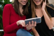 Дві молоді жінки використовують телефон — стокове фото